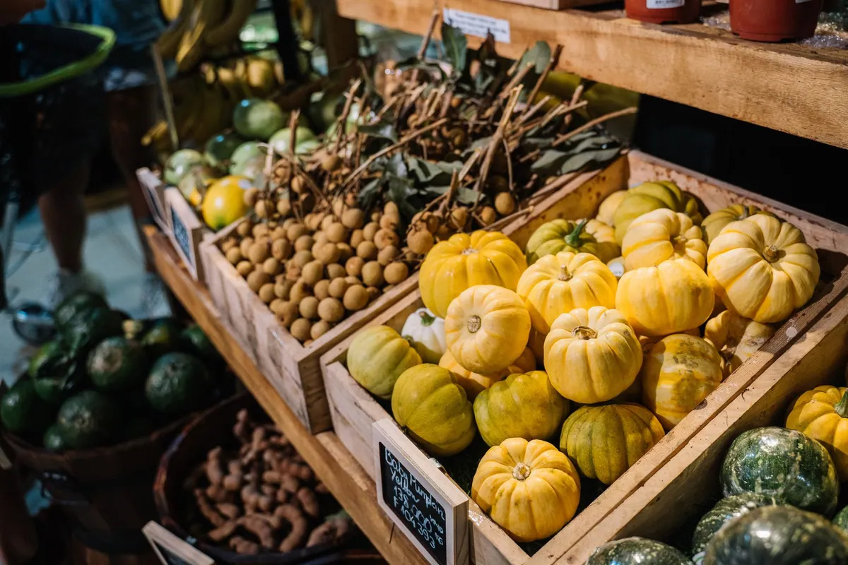 Étal de marché garni de légumes de saison : courges, poireaux, choux, carottes et betteraves disposés en cagettes