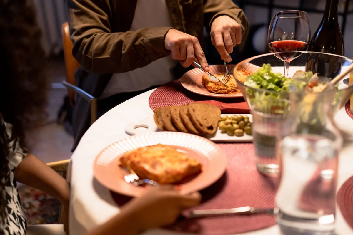 Famille attablée autour d'un repas fait maison, plats partagés au centre de la table