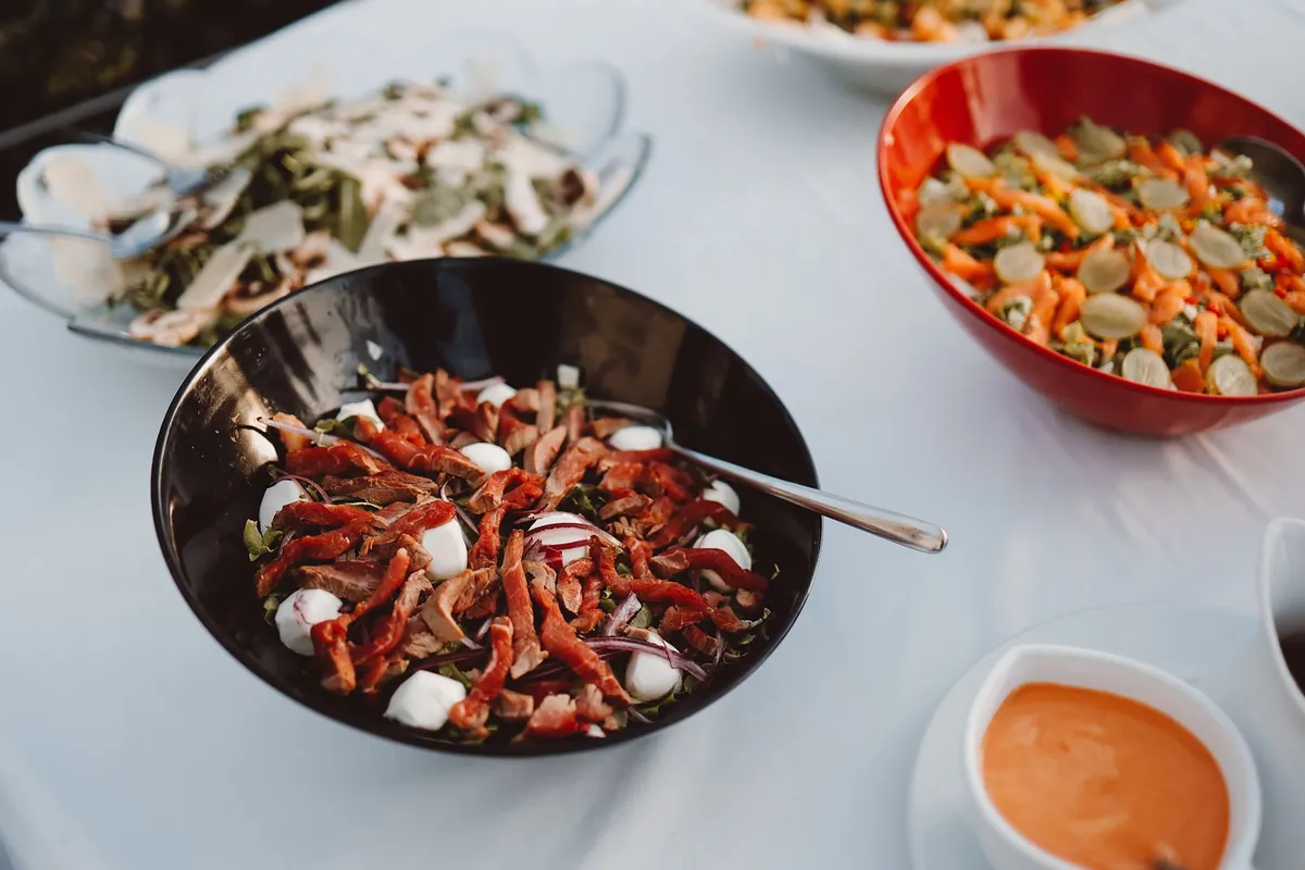 Bol de salade fraîche et colorée dressé sur une table en extérieur, ambiance estivale