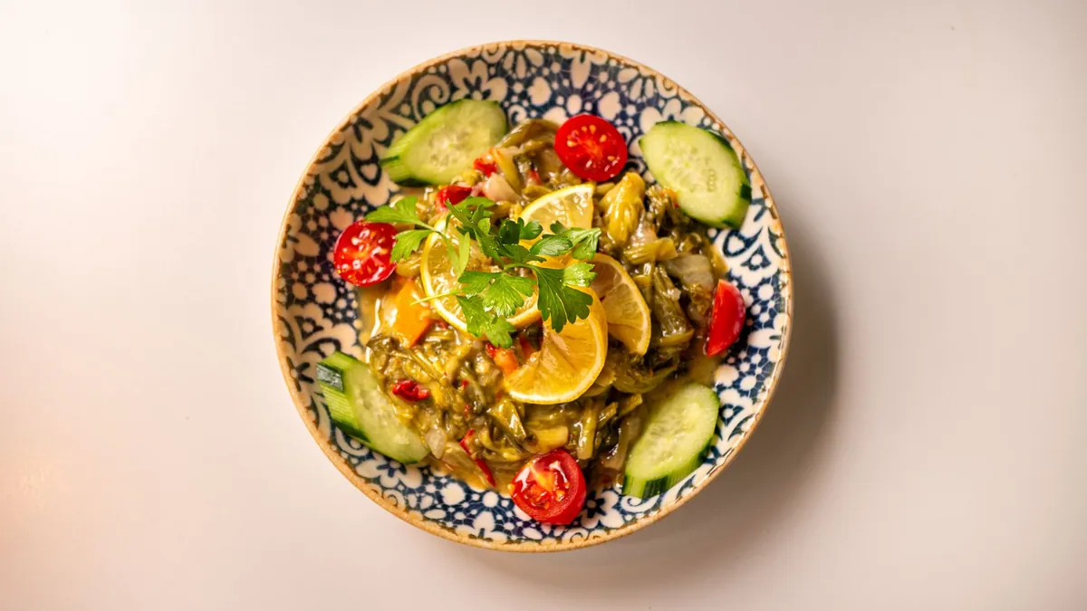 Aubergines imam bayıldı farcies d'oignons et de tomates, confites dans l'huile d'olive, servies froides sur un plat garni de persil et de citron
