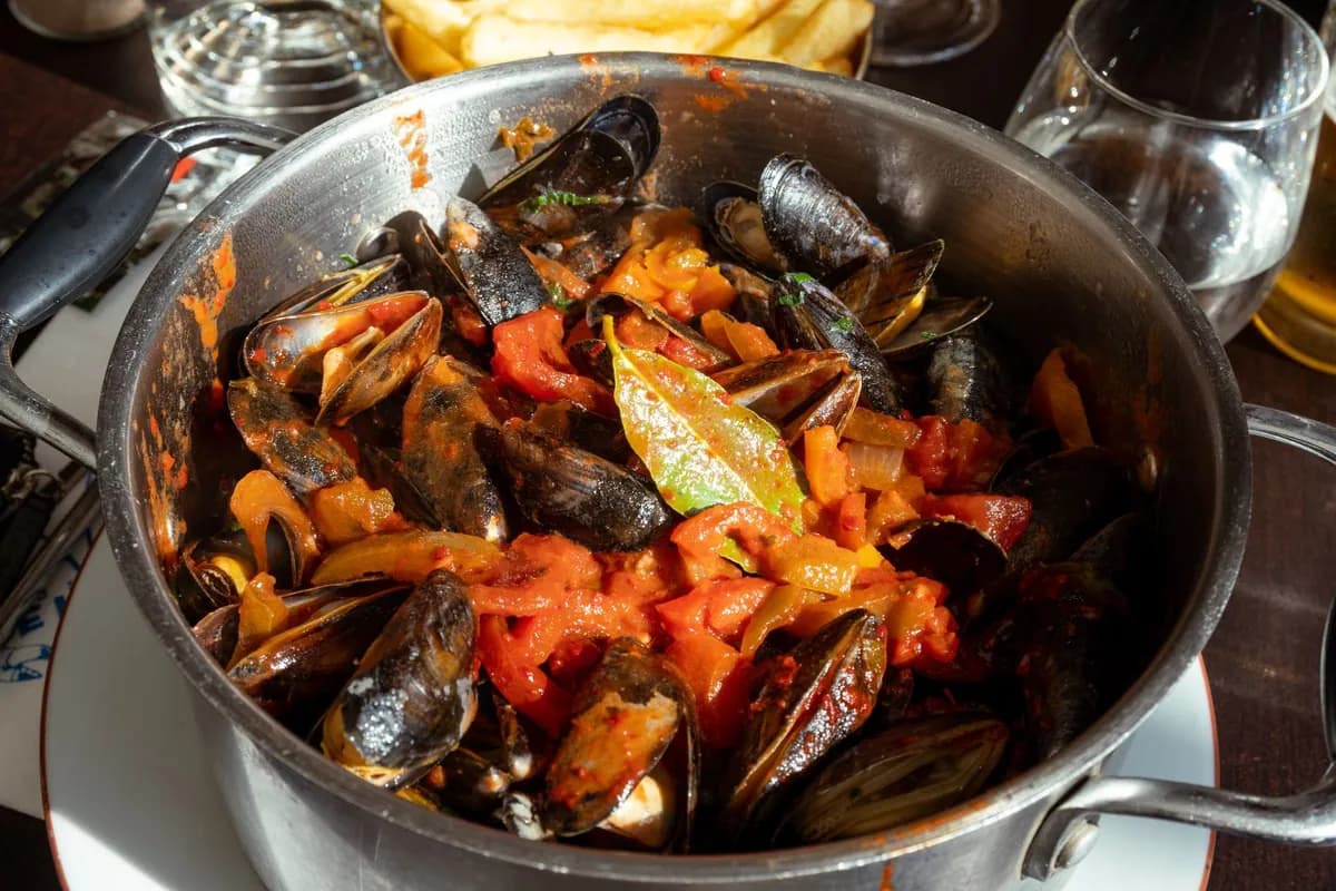Cocotte de jambalaya de Louisiane avec riz créole, saucisse fumée, poulet et crevettes roses, parsemée de persil plat, sur fond d'oignon, poivron et céleri.