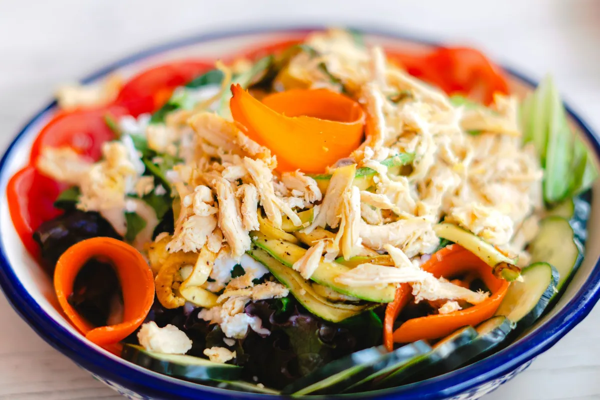 Larb gai, salade thaïlandaise tiède de poulet haché aux herbes fraîches, citron vert et riz grillé moulu, servie avec du riz gluant