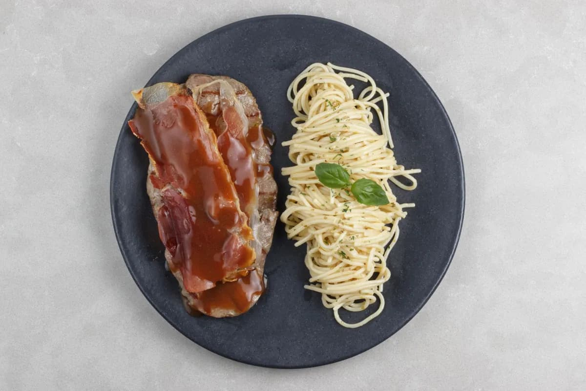 Saltimbocca alla romana : escalopes de veau au jambon de Parme et à la sauge, nappées d'une sauce dorée au vin blanc et au beurre, servies sur assiette chaude
