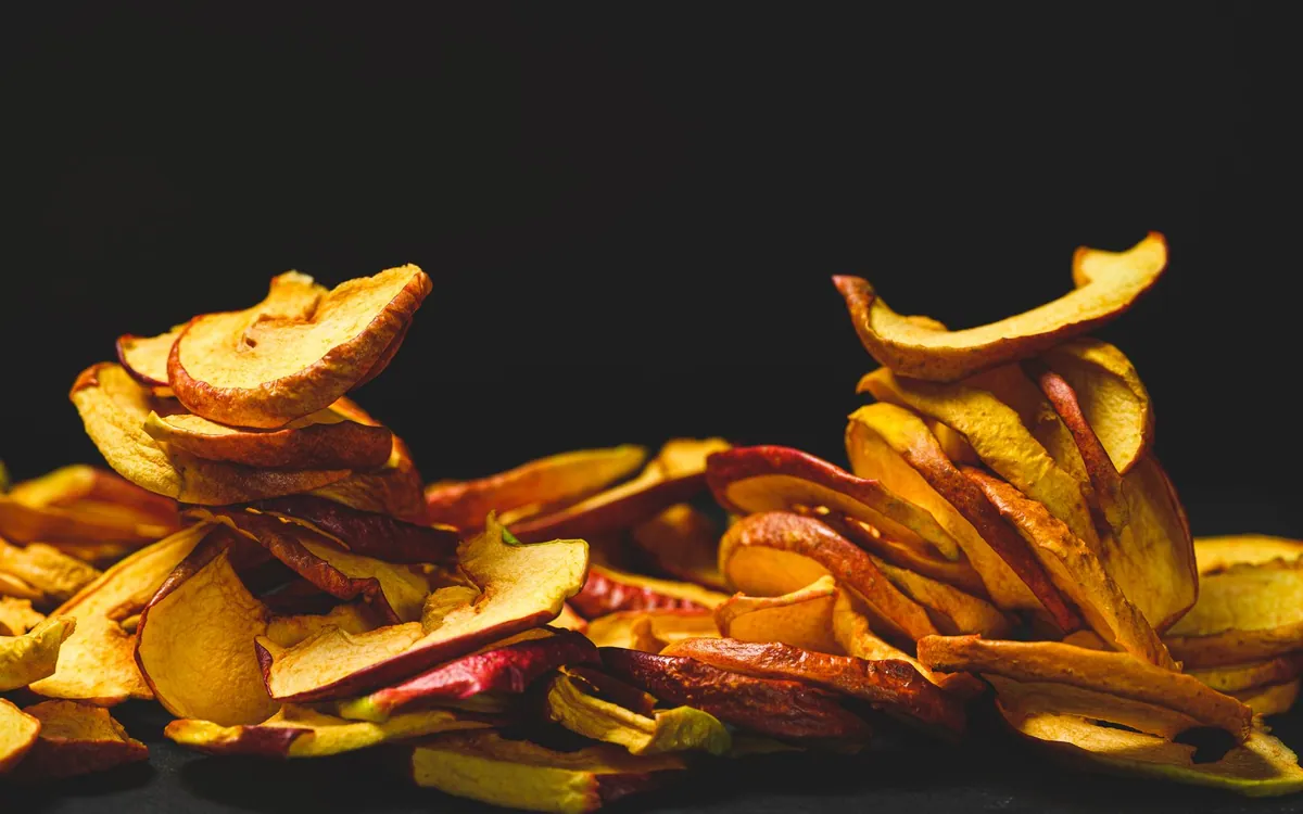 Chips de pomme croustillantes saupoudrées de cannelle sur une plaque