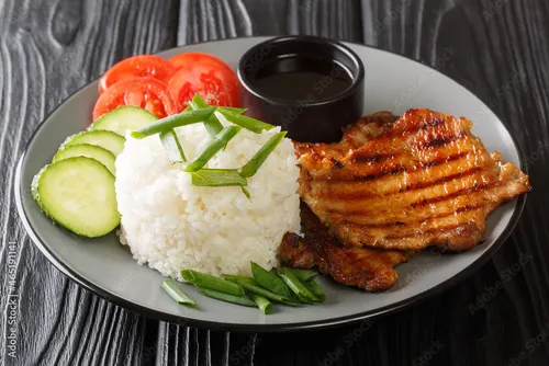Assiette de cơm tấm avec côte de porc grillée, riz brisé, œuf au plat, pickles carotte-daïkon, concombre et huile de cébette, servie avec un bol de nước chấm