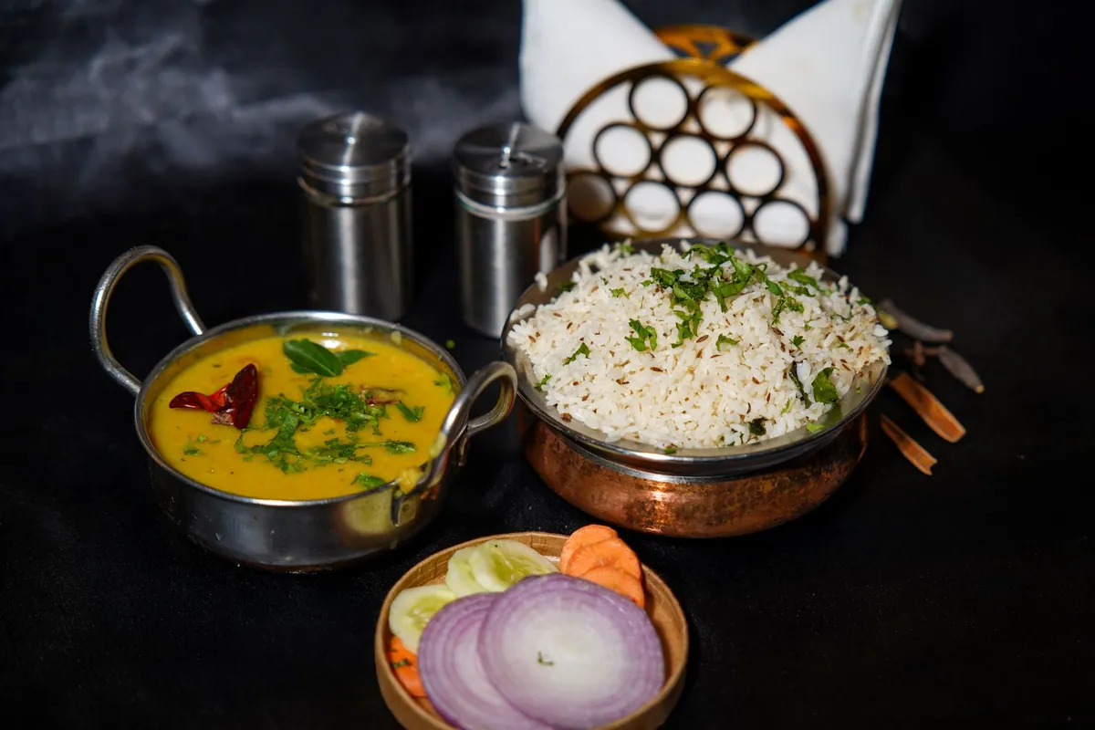 Dal tadka servi dans un bol, lentilles corail crémeuses au curcuma nappées d'un tadka grésillant d'ail, de cumin et de piment, parsemé de coriandre fraîche