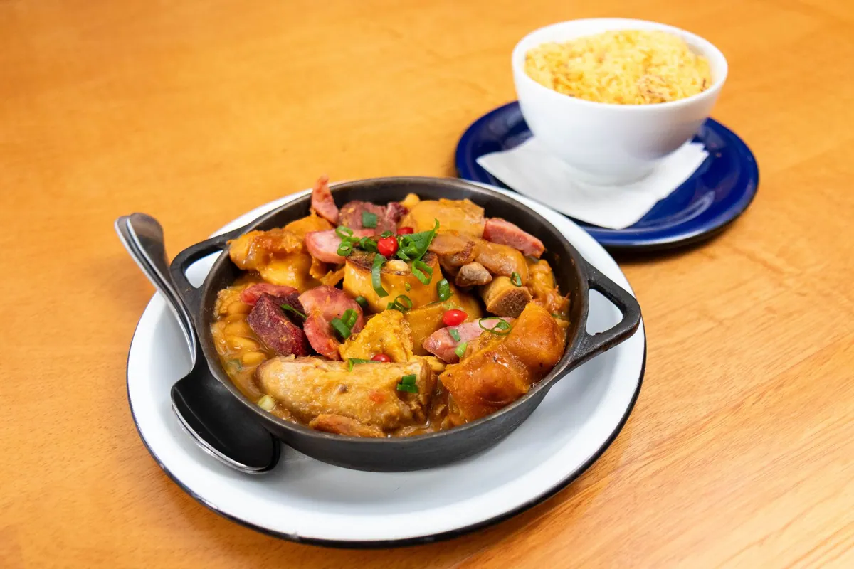Cocotte de jambalaya de Louisiane avec riz créole, saucisse fumée, poulet et crevettes roses, parsemée de persil plat, sur fond d'oignon, poivron et céleri.