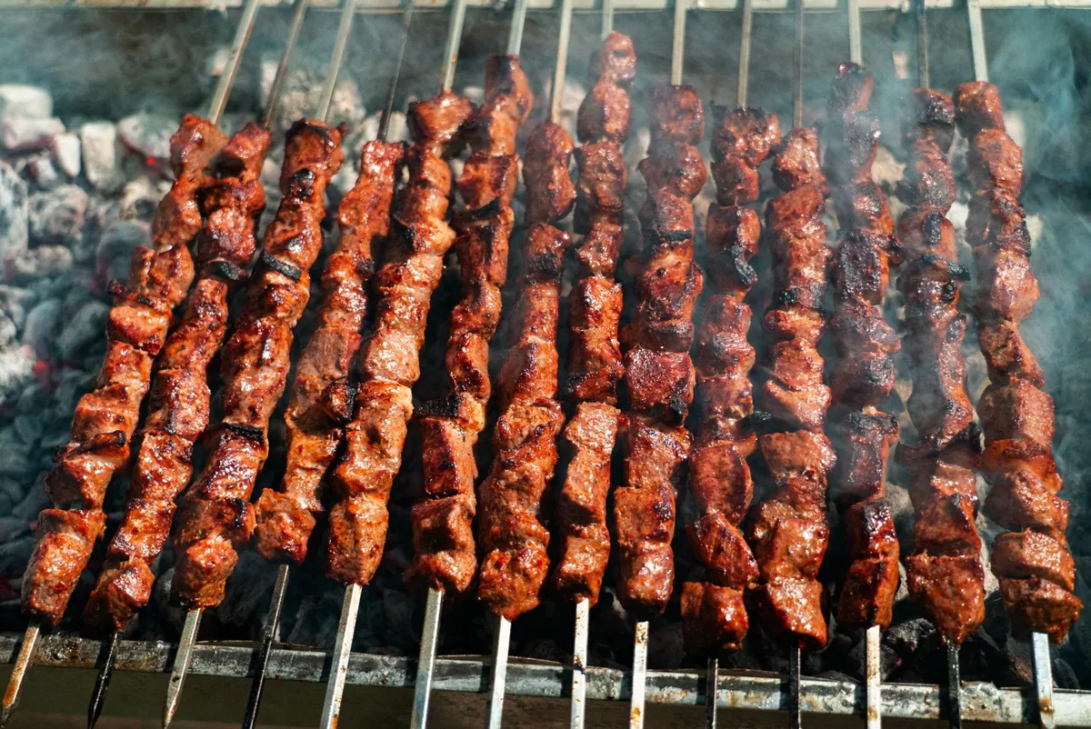 Brochettes de kafta libanaise grillées, viande hachée d'agneau et de bœuf au persil, servies avec du pain pita et du persil frais.