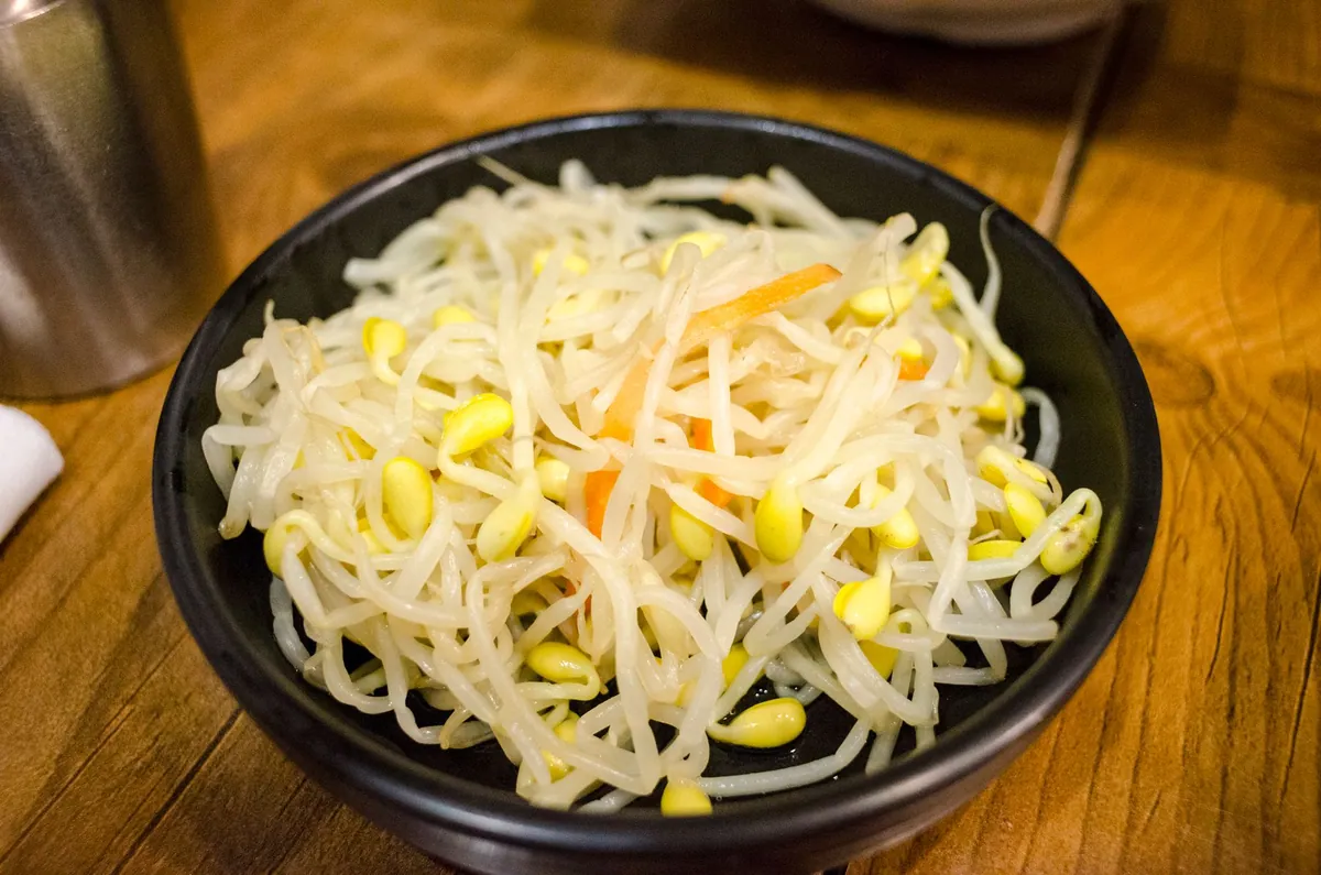 Bol de kongnamul muchim, germes de soja coréens assaisonnés à l'ail, à l'huile de sésame et aux graines de sésame, servi en banchan traditionnel.