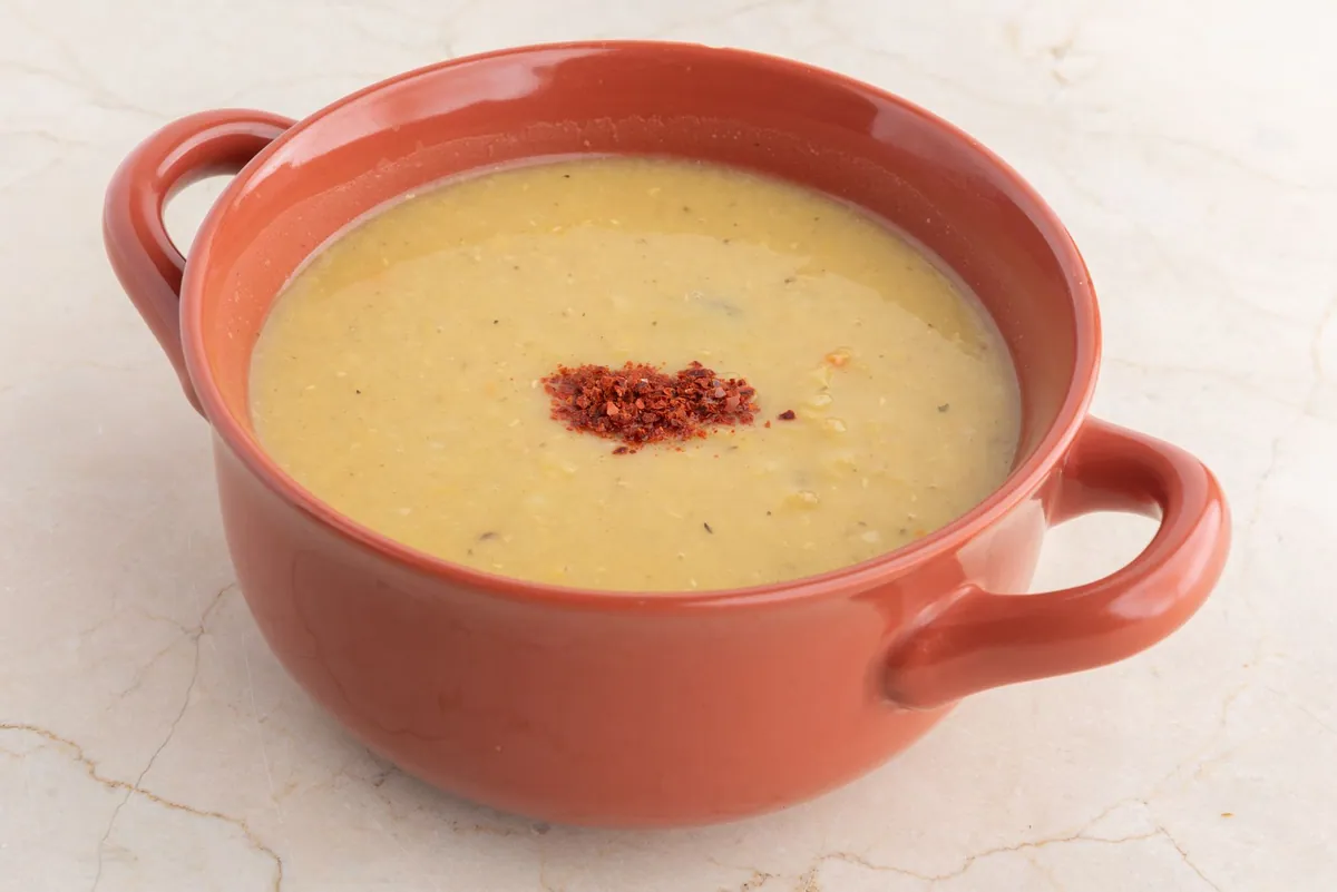 Bol de mercimek çorbası, velouté turc de lentilles corail, garni d'un filet d'huile d'olive, de menthe séchée et d'un quartier de citron.