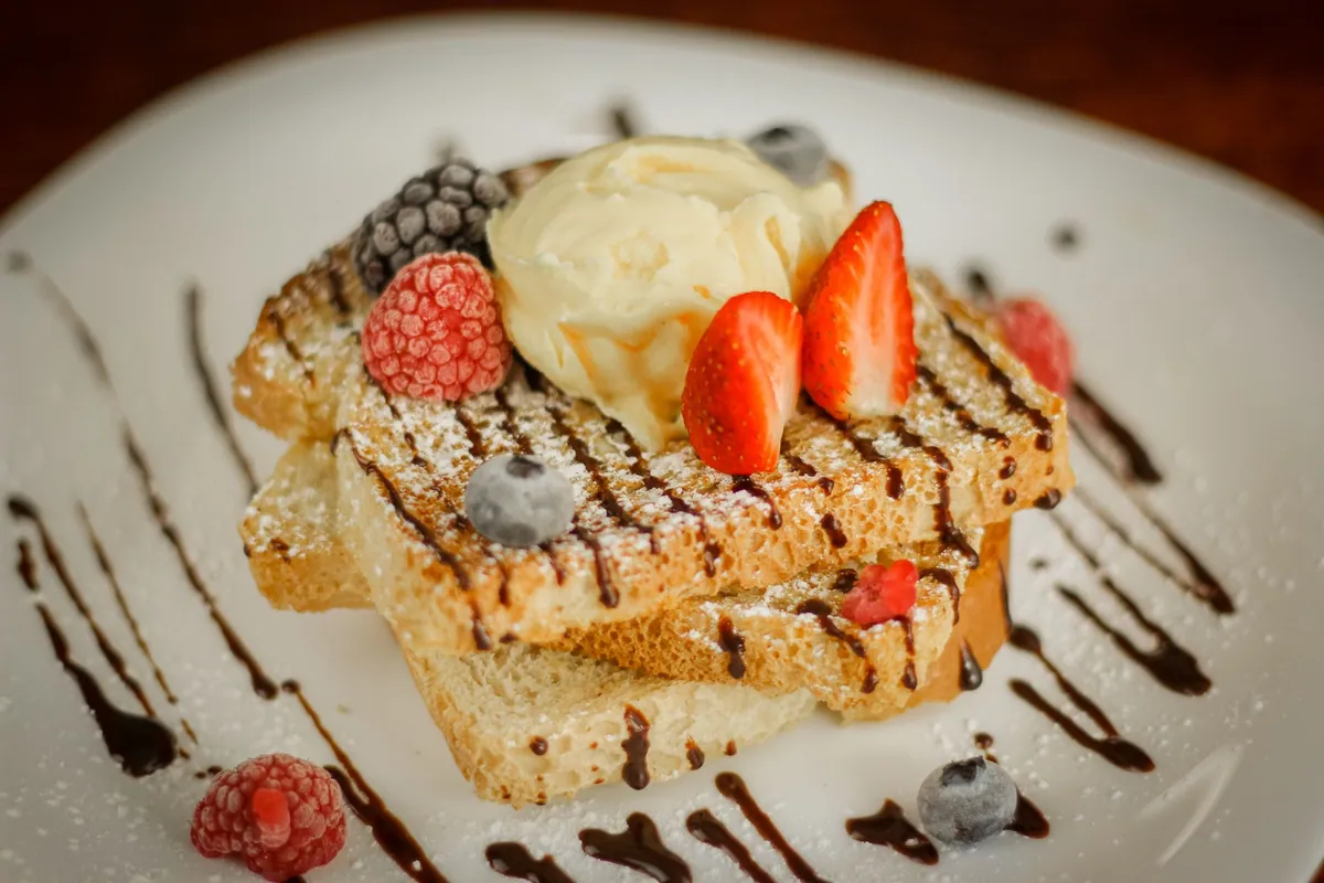 Tranches de pain perdu doré empilées, saupoudrées de sucre glace