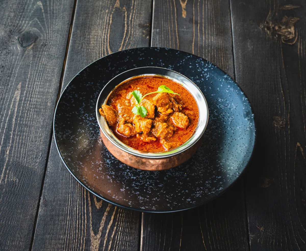 Cocotte de rogan josh d'agneau, sauce rouge au yaourt et épices entières, servie avec du riz basmati