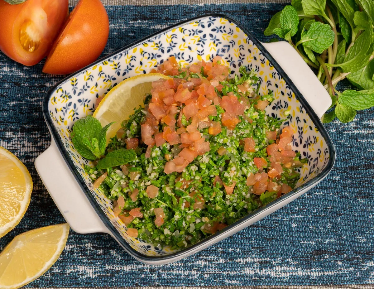 Taboulé libanais dans un saladier, persil finement haché, dés de tomates et menthe fraîche, arrosé de jus de citron et d'huile d'olive
