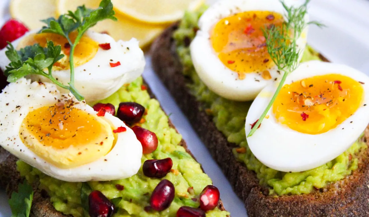 Tartines de pain complet grillé garnies d'avocat écrasé, graines et piment d'Espelette