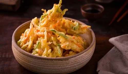 Assortiment de tempura de légumes japonais croustillants, patate douce, aubergine, poivron et shiitake sous une pâte dorée et légère, servi avec sel matcha et citron.